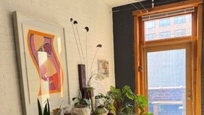 A room with a wooden bench, potted plants, and artwork on the wall. - Artist Loft in the Heart of Chelsea with BBQ & terrace, Pet friendly! (New York)