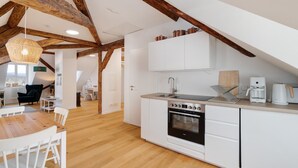 Eine moderne Küche mit weißen Schränken, einem Backofen und einer Kaffeemaschine.