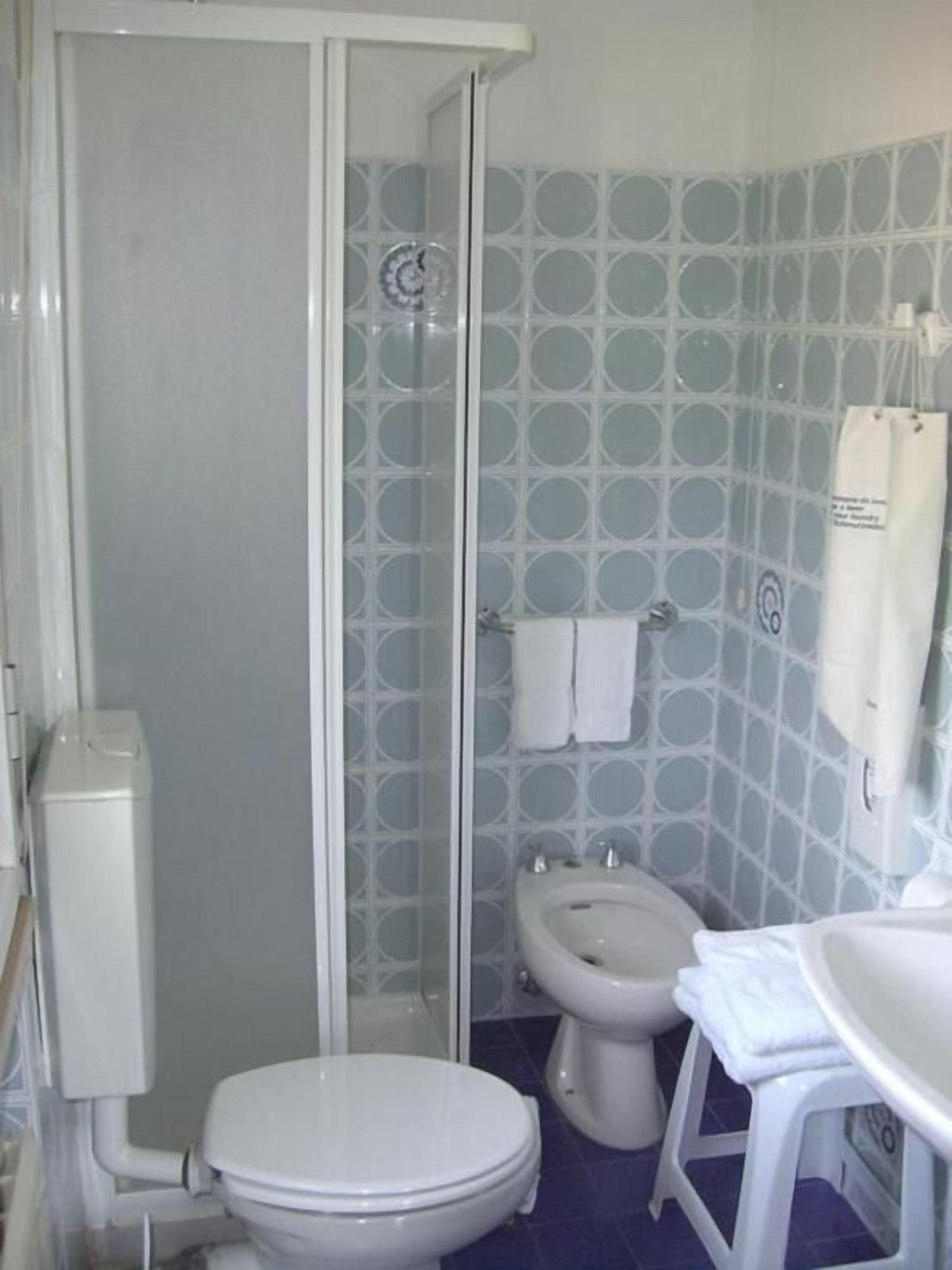 Un bagno con il water, un bidet e uno spazio doccia.