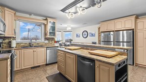 Una cocina moderna con armarios color beige, electrodomésticos de acero inoxidable y una isla grande.