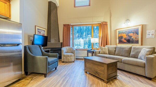 A modern living room with a fireplace, a television, a sofa, and a coffee table.