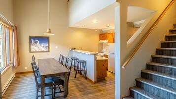 A modern kitchen with wooden cabinets, a central island, and a built-in oven.