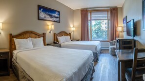 A hotel room with two beds, a desk, a chair, a TV, and a window with curtains. - Cahilty #154 Hotel Room (Sun Peaks)