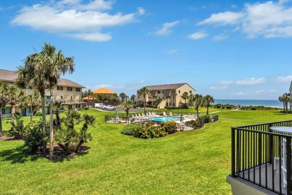 A resort with a swimming pool, palm trees, and ocean views. - Summerhouse 147 2 Bedroom Condo (St. Augustine)