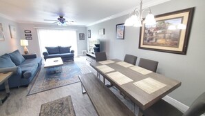 Un salon comprenant un canapé, une table basse et une table à manger avec des chaises.