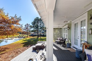 Une terrasse couverte avec des meubles d’extérieur, une petite piscine et une vue sur un quartier résidentiel.