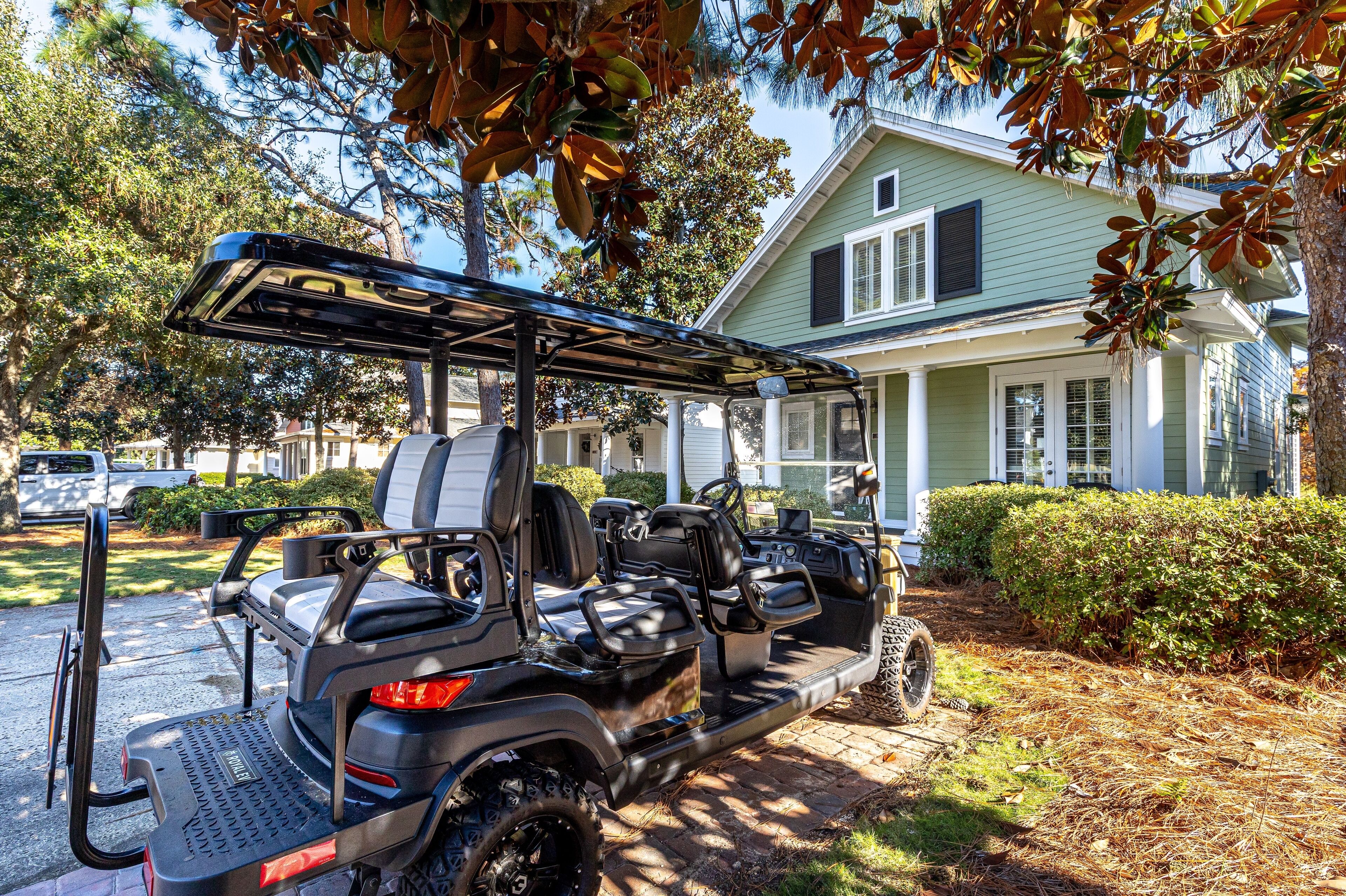 Une voiturette de golf est garée sur une allée, avec une maison en arrière-plan.