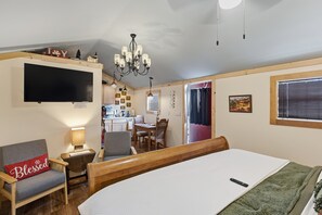 A cozy room with a bed, a desk, a chair, a TV, and a chandelier. - Blitzen - Reindeer Ranch At Round Top Cabin (Ledbetter)
