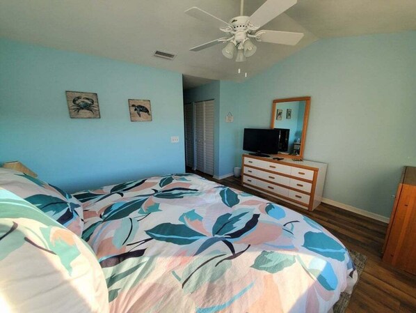 A bedroom with a bed, a dresser, a television, and a ceiling fan. - Spyglass 13 2 Bedroom Condo (St. Augustine)