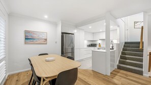 A modern kitchen with white cabinets, a refrigerator, and a microwave. - Flynns Beach Retreat, 3 of 3 Everard street (Port Macquarie)