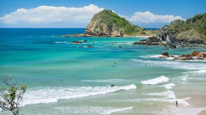 A coastal landscape with clear turquoise waters, rocky outcrops, and a prominent hill. - Flynns Beach Retreat, 3 of 3 Everard street (Port Macquarie)