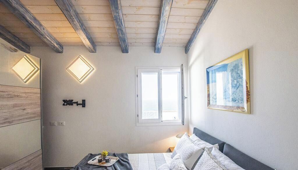 Ein Schlafzimmer mit einem Bett, einem Fenster und einer Wandleuchte.