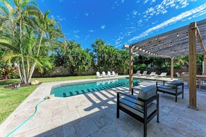 A pool area with lounge chairs and a pergola. - Fully renovated 5 bedroom pool home (Sarasota)