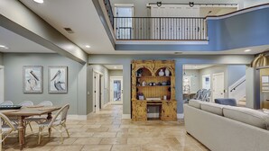A spacious interior with a dining area, a central seating area, and a staircase leading to an upper level. - 50 Dune Lane – NFB Oceanside Retreat- Private Pool, Steps from the Beach (Hilton Head Island)