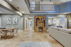 A spacious interior with a dining area, a central seating area, and a staircase leading to an upper level. - 50 Dune Lane – Spacious Oceanside Retreat- Private Pool, Steps from the Beach (Hilton Head Island)