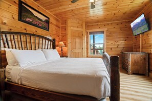 A wooden room with a bed, a television, and a window. - Handicap Friendly Cabin Retreat・Pool Table・Grill (Pigeon Forge)