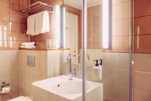 A bathroom with a sink, mirror, towel rack, and glass shower enclosure. - Scandic Go, Lilla Bommen 5 (Gothenburg)