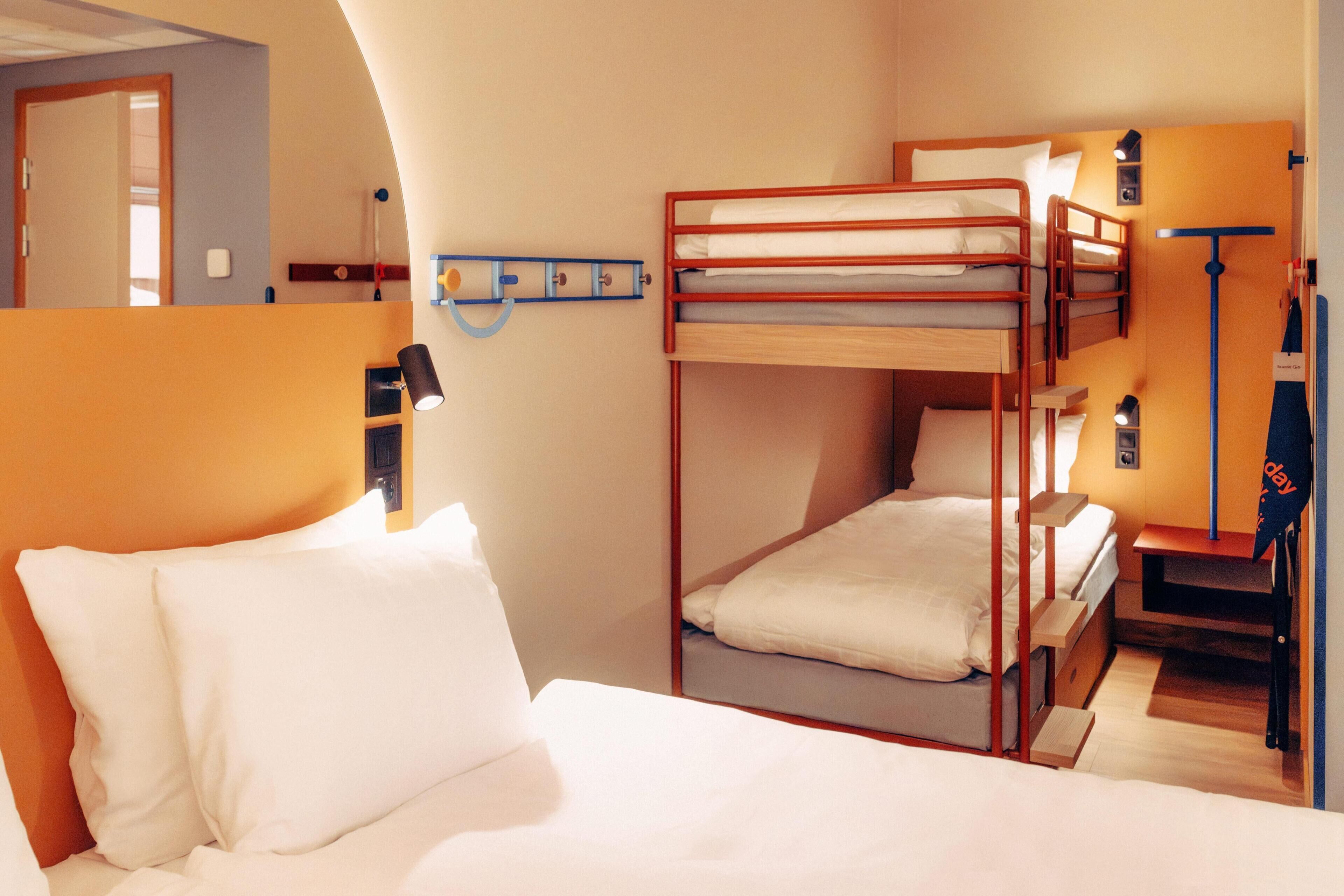 Een slaapkamer met een stapelbed, bureau en lamp.