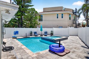 Ein Garten mit Swimmingpool, Whirlpool und weißem Zaun.