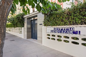 A building entrance with a sign reading 'EDIFICIO GANDIAZAR II' and a door with a keypad lock. - Apartment with Ocean View 10, Gandía (Grau i Platja)