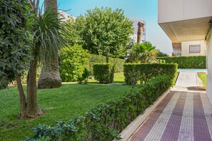 A well-maintained garden with a pathway leading to a building. - Apartment Sea View 10 Gandía (Grau i Platja)