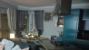 A modern kitchen with a built-in stove and a blue refrigerator. - Caravan - Sleeps 6 - Short Walk to Rhyl Beach (Rhyl)