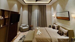 Une chambre à coucher moderne, équipée d’un lit, d’un ventilateur de plafond, d’une télévision et d’un luminaire décoratif.