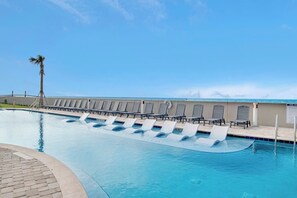Ein Swimmingpool mit Liegestühlen und einer Palme.