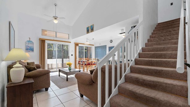 Ein geräumiges Wohnzimmer mit einer Couch, einem Couchtisch und einer Treppe, die zu einer weiteren Ebene führt.
