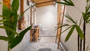 A small, private bathroom with a wooden ceiling, a toilet, a sink, and a shower area. - D'Lagoon Dive Resort (Pulau Lembeh)