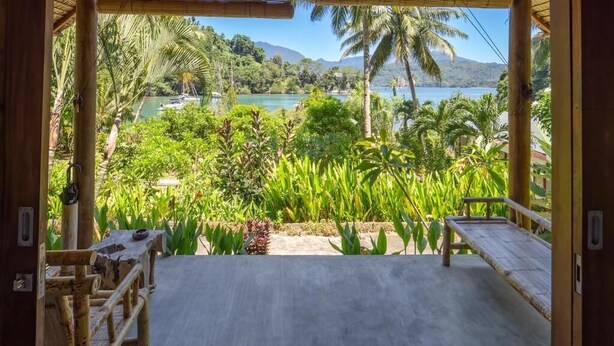 A room with a view of a tropical beach and palm trees. - D'Lagoon Dive Resort (Pulau Lembeh)