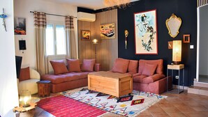 Ein Wohnzimmer mit einem Ecksofa, einem Holztisch und einem gemusterten Teppich.