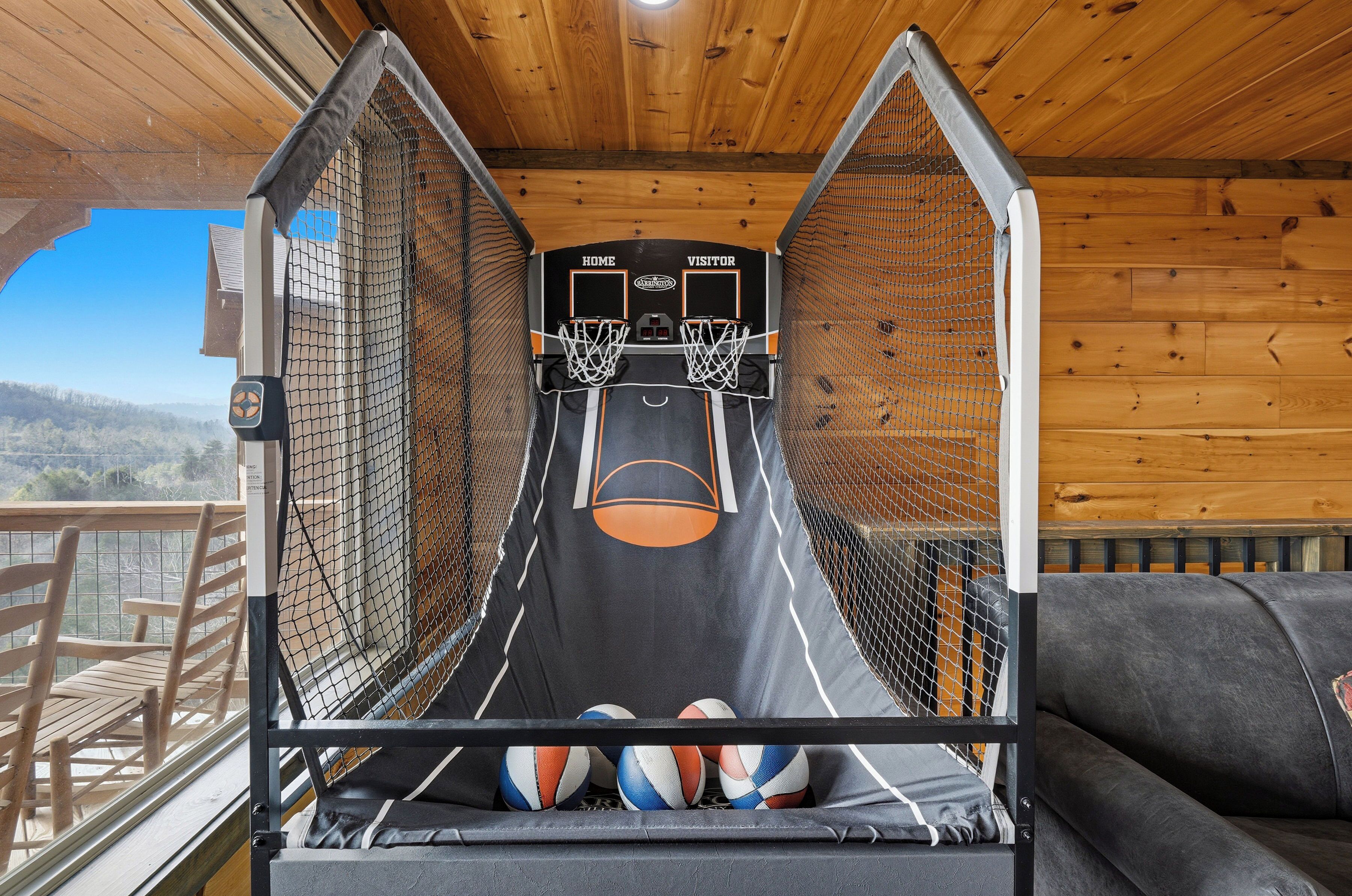Ein Basketballfeld mit zwei Körben, einer Couch und Blick ins Freie.