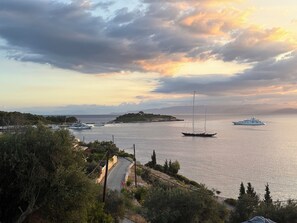 A coastal view with boats, a road, and a hilly landscape. - Villa Avgerini Paxos II: Stunning sea views, private terrace and Infinity pool (Gaios)