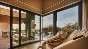A modern living room with a large sliding glass door leading to an outdoor patio area. - Deluxe Villa Brtonigla with heated pool (Brtonigla)