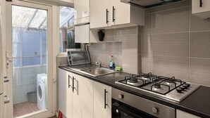 Une cuisine moderne avec des armoires blanches, une cuisinière à gaz et un four encastré.