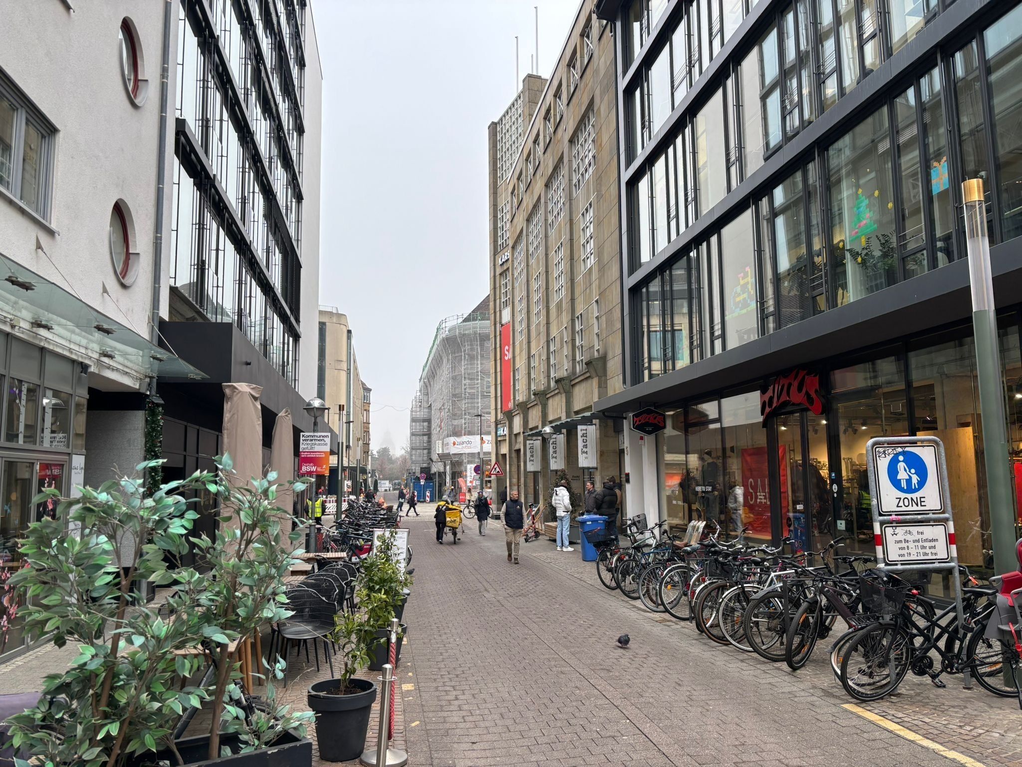 Una calle bordeada de tiendas y bicicletas estacionadas a lo largo de la acera.