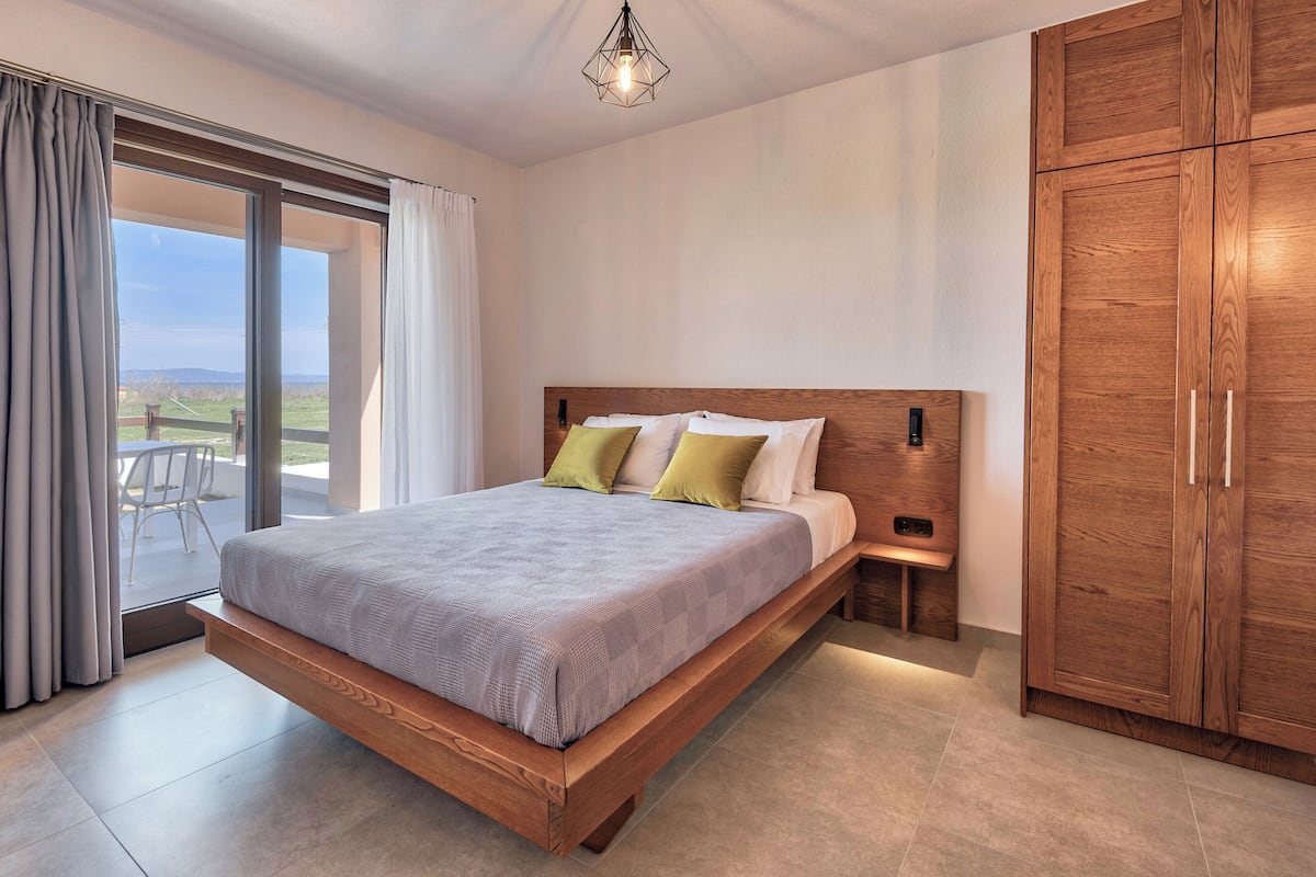 Ein Schlafzimmer mit einem großen Bett, einem hölzernen Kopfteil, Nachttischen und einem Kleiderschrank.