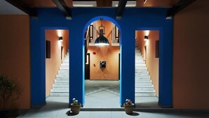 Een modern interieur met een centrale trap, begrensd door blauwe wanden en witte treden.