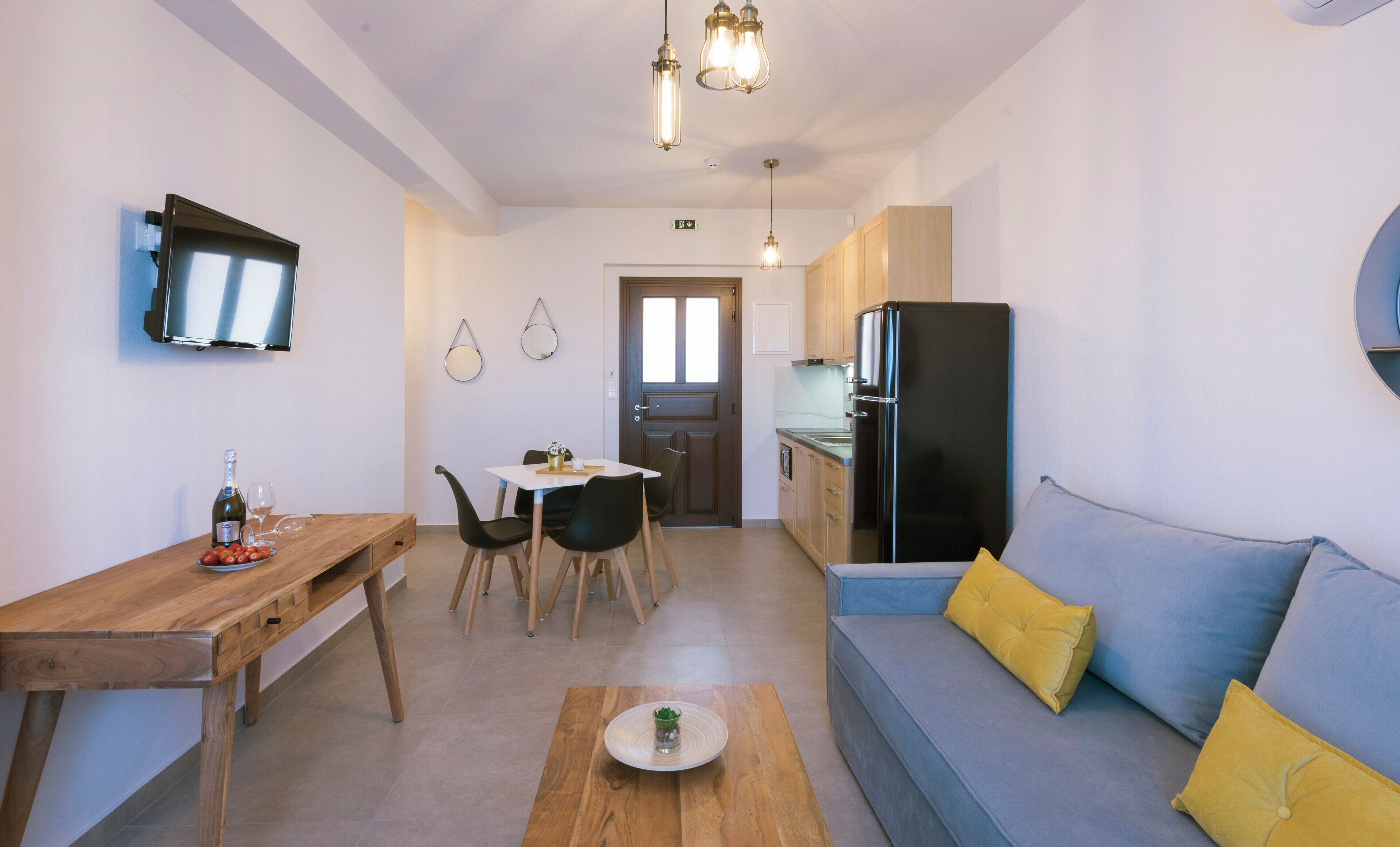 Un espacio habitable compacto con kitchenette, comedor y zona de estar.