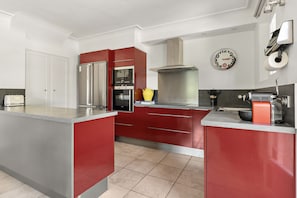 Una cocina moderna con armarios rojos, electrodomésticos de acero inoxidable y una isla grande.