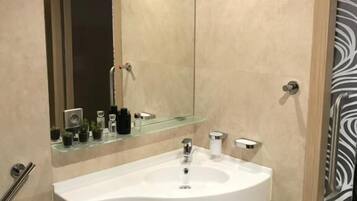 Ein modernes Badezimmer mit Waschbecken, Spiegel und Handtuchhalter.