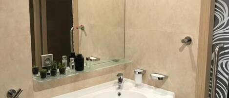 A modern bathroom with a white sink, mirror, and towel rack.