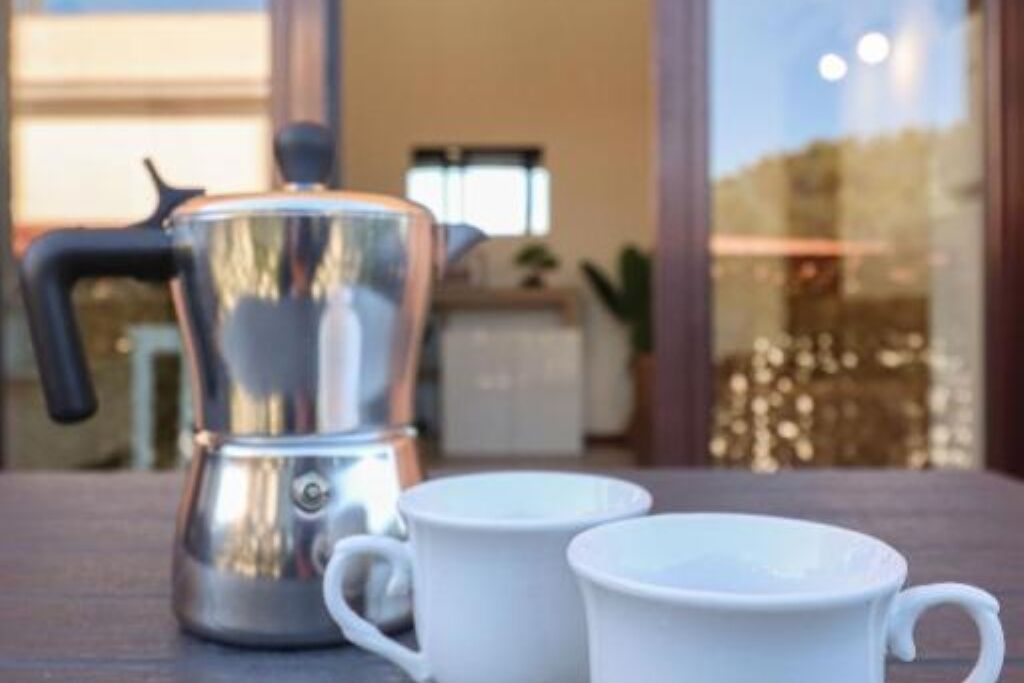 Eine Kaffeemaschine auf einem Tisch mit zwei weißen Tassen.