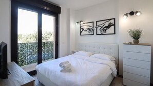 Ein Schlafzimmer mit einem Bett, einem Fernseher, einer Kommode und Bildern an der Wand.