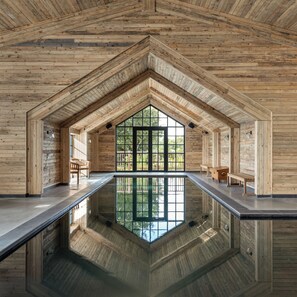 A modern interior with a large glass window, wooden walls, and a reflective pool. - Louma Country Hotel (Bridport)