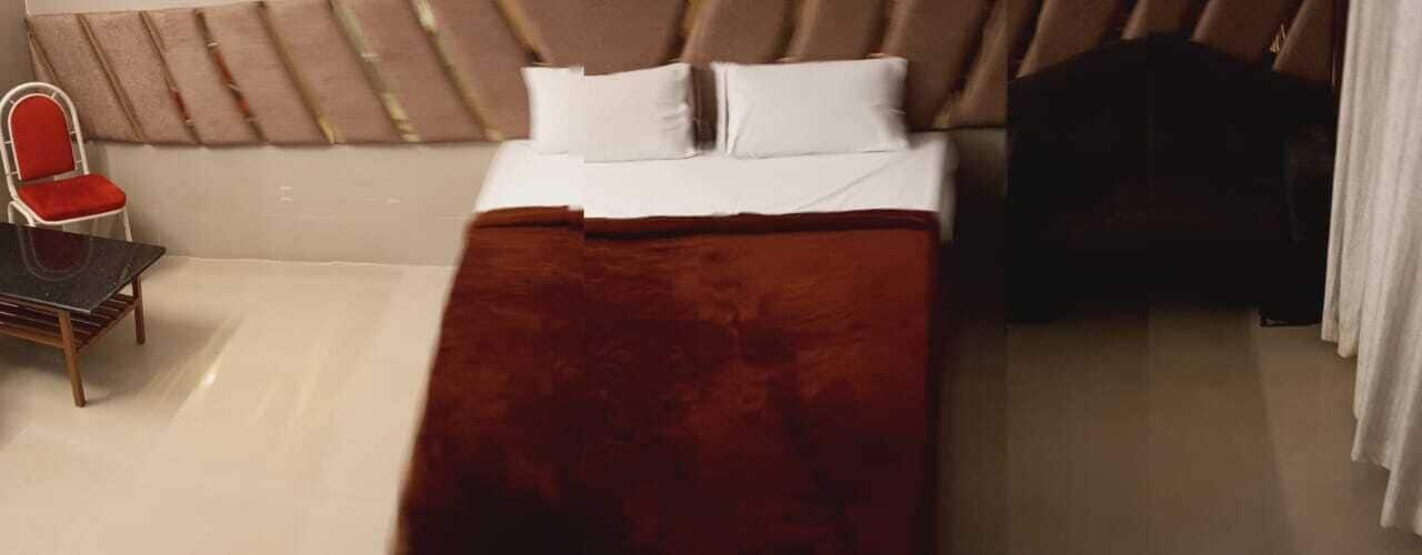 A hotel room with a bed, a chair, and a table.