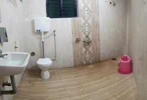 Un baño con lavamanos, inodoro y ventana.