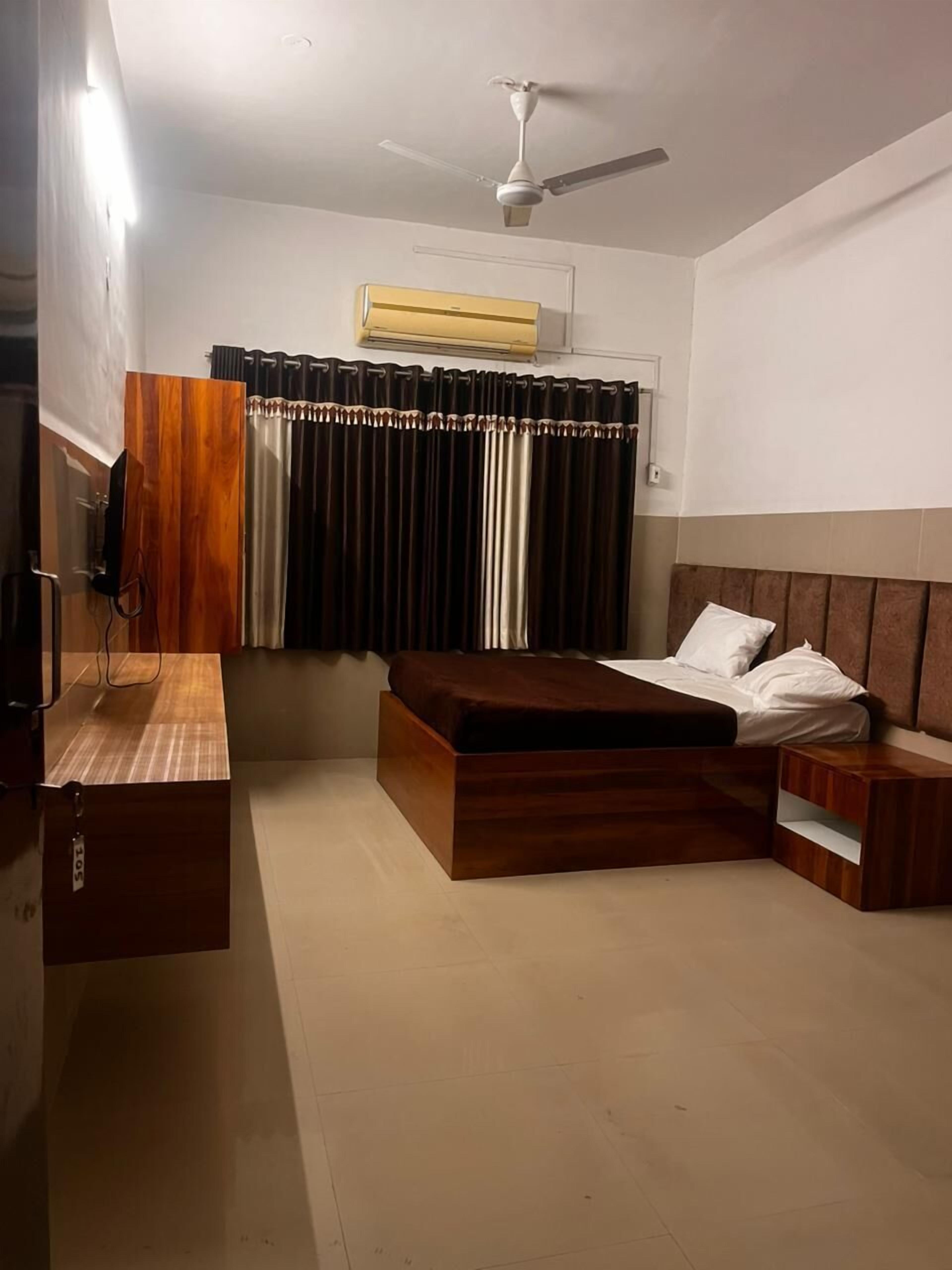 Un dormitorio con cama, mesitas de noche, armario y ventilador de techo.