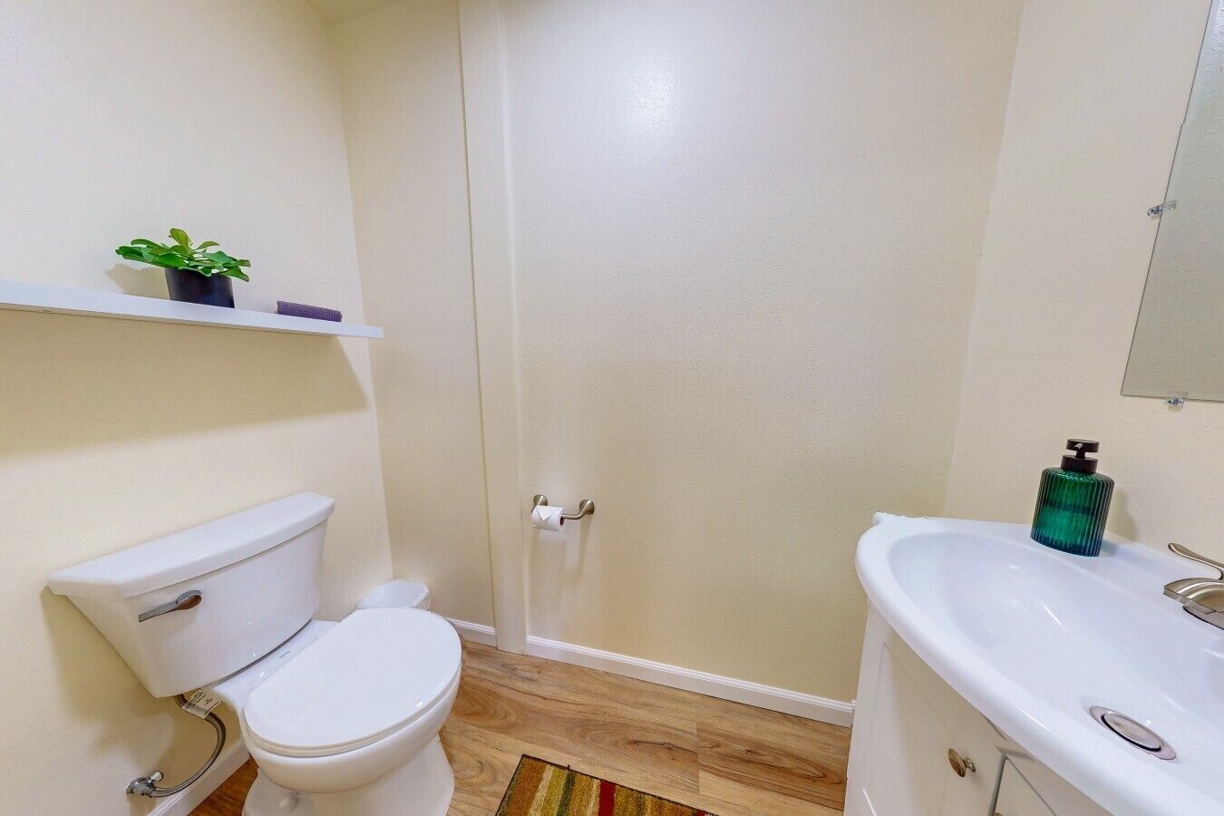 A bathroom with a toilet, a shower, and a sink.